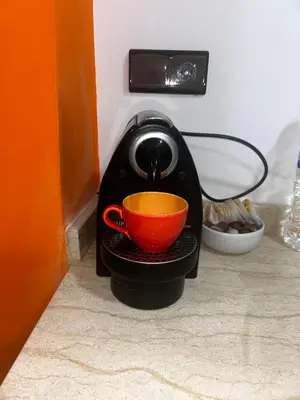 a tea kettle with a red cup in it at Olive & Orange Modern Studio in Rabat