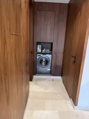 a washer and dryer in a room with a door at Suite Cozy Design Suite Maarif, Close to Ain Diab in Casablanca