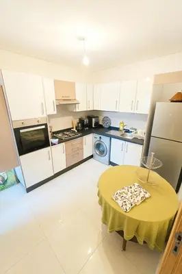 a kitchen with a table with a yellow table cloth on it at Vue Piscine Idéal pour Supporters Transfert in Mansouria