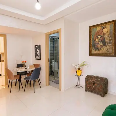 a dining room and living room with a table and chairs at Vue Piscine Idéal pour Supporters Transfert in Mansouria