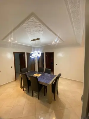 a dining room table and chairs in a room at Charming Apartment in Temara Near Beach & Rabat in Temara