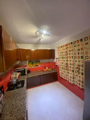a kitchen with red walls and a kitchenasteryasteryasteryasteryasteryasteryasteryastery at Charming Apartment in Temara Near Beach & Rabat in Temara