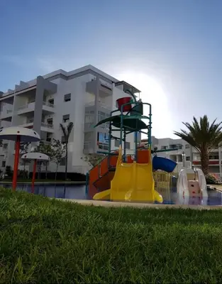 a playground with a slide in front of a building at La Siesta Beach Appartement in Mohammedia