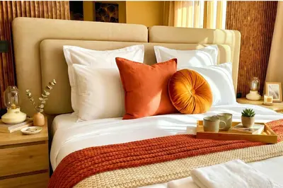 a bed with orange and white pillows and a tray on it at Maya Suites - Habous Old Town - Panoramic City View in Casablanca