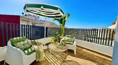 a balcony with two chairs and a table and an umbrella at Maya Suites - Habous Old Town - Panoramic City View in Casablanca