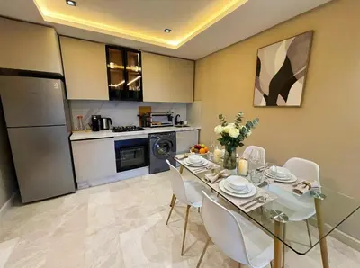 a dining room with a table and white chairs at Maya Suites - Habous Old Town - Panoramic City View in Casablanca