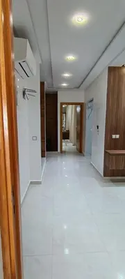 a room with a white tile floor and a hallway at Temara wifak in Temara
