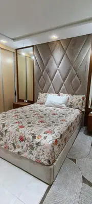 a bedroom with a large bed with a large headboard at Temara wifak in Temara