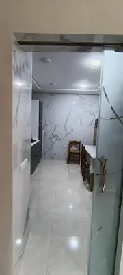 a room with a hallway with a table and a refrigerator at Samir in Temara