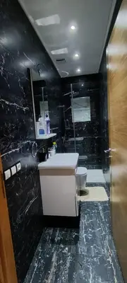 a black bathroom with a sink and a toilet at Samir in Temara