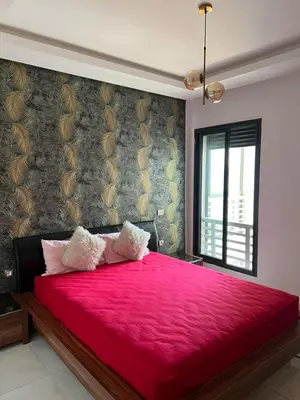 a bedroom with a red bed with a red blanket at Costa in Bouznika