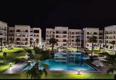 a view of a resort at night at Costa in Bouznika