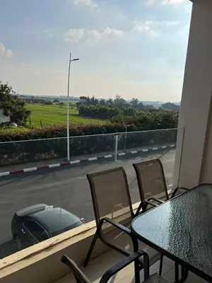 a balcony with a table and chairs and a car on the street at Costa in Bouznika