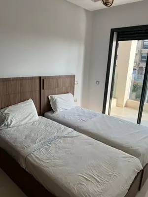 two beds sitting next to each other in a bedroom at Costa in Bouznika