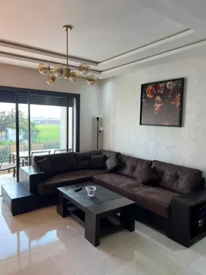 a living room with a brown leather couch and a table at Costa in Bouznika
