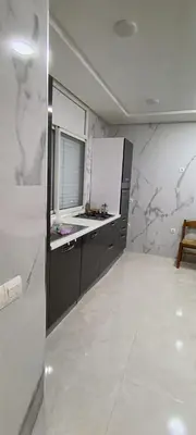 a kitchen with white marble walls and a counter at Temara wifak in Temara