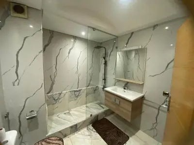 a bathroom with a shower and a sink and a mirror at Casablanca Comfortable City-Centre Apartment in Casablanca