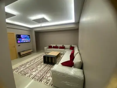 a living room with a couch and a tv at Casablanca Comfortable City-Centre Apartment in Casablanca