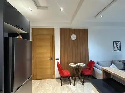 a kitchen and dining room with a table and red chairs at Modern Apartment in Maarif Princess in Casablanca