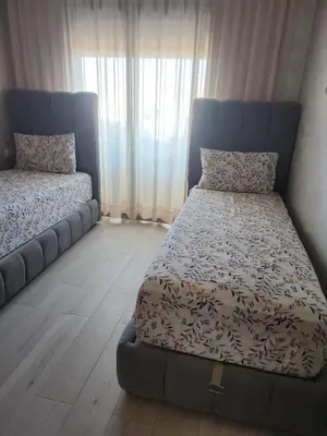 a bedroom with a bed and a couch at Diha Appartement in Sidi Rahal
