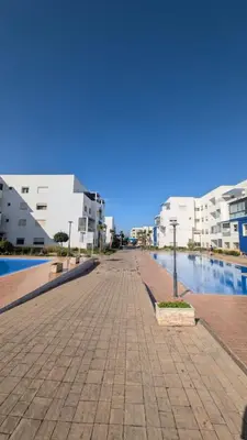 a sidewalk in a city with buildings and water at Blue Haven Pool Suites in Pont Blondin