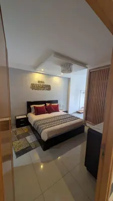 a bedroom with a large bed with red pillows at Blue Haven Pool Suites in Pont Blondin