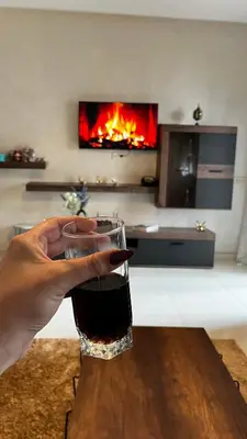 a person holding a glass of wine on a table at Magic house in Mansouria
