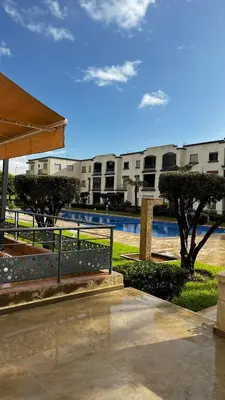 a building with a fence next to a swimming pool at Magic house in Mansouria