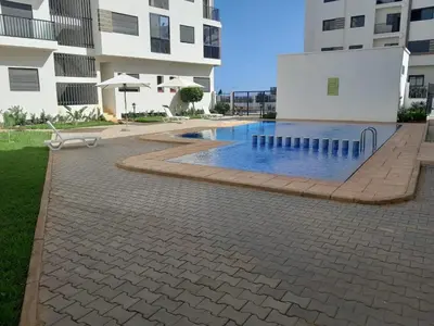 a swimming pool in front of a building at Dar Lakbira Bouznika in Bouznika