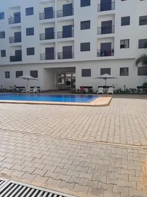 a building with a swimming pool in front of a building at Dar Lakbira Bouznika in Bouznika