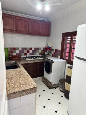 a kitchen with a stove and a microwave in it at Petit Apparemment pas chère à 3km du grand stade de rabat in Temara