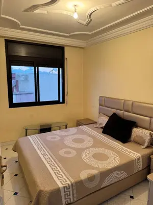 a bedroom with a large bed with a window at Petit Apparemment pas chère à 3km du grand stade de rabat in Temara