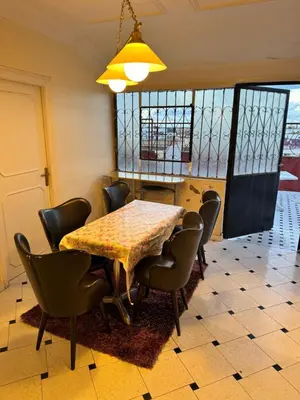 a dining room with a table and chairs at Petit Apparemment pas chère à 3km du grand stade de rabat in Temara
