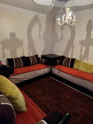 a living room with a couch and a chandelier at Petit Apparemment pas chère à 3km du grand stade de rabat in Temara