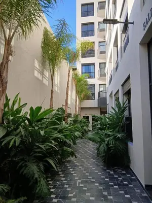 a courtyard with palm trees in front of a building at BeauLiving Park in Casablanca