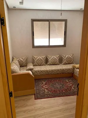 a couch in a room with a window and a rug at Bouznika in Bouznika