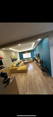 a living room with yellow couches and a blue wall at oceon vue rabat center in Rabat