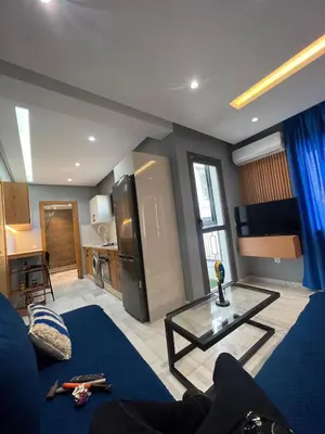 a living room with a blue couch and a table at Le studio Chic in Casablanca
