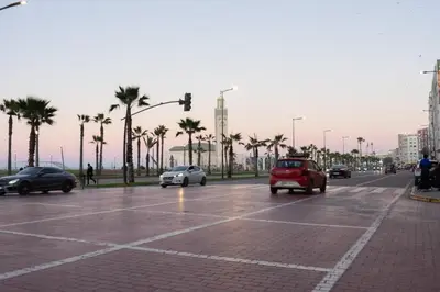 a street with cars driving down a street with palm trees at Luxury Studio near to H2M Area in Casablanca