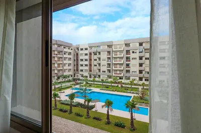 a view from a window of a building with a swimming pool at Elegance - 2 bedrooms with Pool - 5 min Airport in Nouaseur