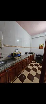 a kitchen with a checkered floor and a counter top at Targuist in Settat