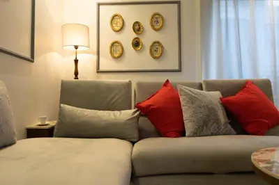 a couch with pillows and clocks on the wall at Luxury Studio near to hassan 2 in Casablanca