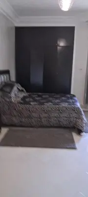 a bed with a black comforter on top of it at Appartement près de la corniche in Casablanca