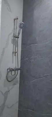 a shower in a bathroom with a stone wall at Appartement près de la corniche in Casablanca