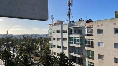 a tall building with palm trees and a city at Love appartement1 in Casablanca