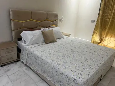 a bedroom with a large bed with a headboard at Love appartement1 in Casablanca