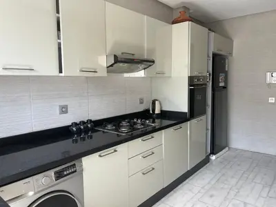 a kitchen with white cabinets and a stove top oven at Love appartement1 in Casablanca
