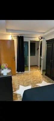 a living room with a wooden floor and a table at Appartement meublé à louer in Rabat