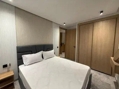 a bedroom with a large white bed and wooden cabinets at Studio luxe Centre ville in Casablanca