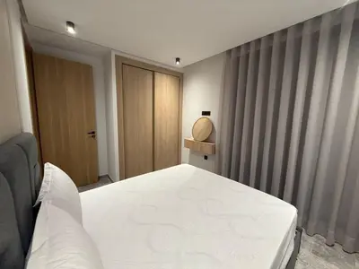 a bedroom with a white bed and a wooden door at Studio luxe Centre ville in Casablanca